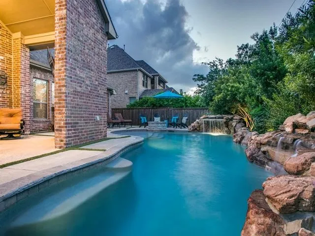 Natural pool with waterfall and rock edge in Frisco