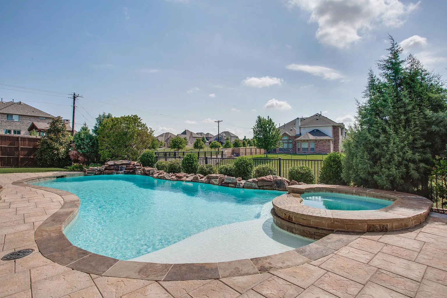 Natural pool with waterfall and rock edge in Frisco