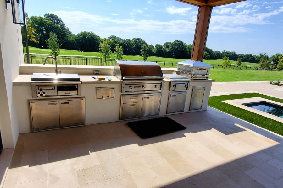 Modern outdoor kitchen with stone counters and built-in grill